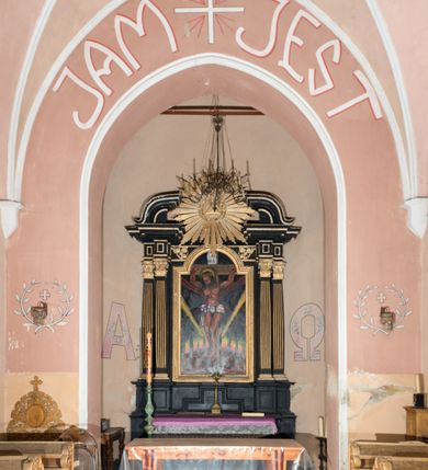 Zdjęcie nr 24: Kościół jest jednonawowy, trójprzęsłowy, z płytkimi kaplicami tworzącymi pseudotransept i jednoprzęsłowym prezbiterium zakończonym apsydą. Do prezbiterium przylegają dwa aneksy mieszące w przyziemiu zakrystię i skarbczyk, a na piętrze empory otwarte na prezbiterium. Do nawy od południa dostawiona jest kruchta. W naroża między kaplicami a nawą wstawiono dwie wieże-dzwonnice z klatkami schodowymi prowadzącymi na empory. Nawa jest rozczłonkowana płaskimi, szerokimi pilastrami toskańskimi, a nakryta sklepieniem kolebkowym z lunetami; prezbiterium przykryte sklepieniem kolebkowym z żebrami spływającymi na wsporniki, apsyda sklepieniem parasolowatym.  Prezbiterium ujęte dwiema głębokimi, półkoliście zamkniętymi wnękami, nad którymi parapety empor z ślepymi arkadkami z balasów jenolalkowych i łuków półkolistych. Wnętrze oświetlają wysokie i szerokie okna zamknięte półkoliście. W aneksach przy prezbiterium i w emporach znajdują się okna prostokątne. Fasada dwustrefowa, trójosiowa, ale osie i strefy wyznaczone jedynie przez okna, drzwi i nisze, zamknięta trójkątnie.    
Portal prostokątnych drzwi utworzony z pary żłobkowanych, toskańskich pilastrów, podtrzymujących belkowanie z trójkątnym przyczółkiem. Fryz belkowania ozdobiony tryglifami z łezkami i metopami w kształcie rozet i talerzy, a przyczółek kostkowaniem. Nad portalem okno w głębokim rozglifieniu, w kształcie prostokąta zamkniętego półkoliście. Po bokach portalu i okna głębokie nisze ujęte od dołu i góry odcinkami gzymsu. Zewnętrzne elewacje ujęte częściowo szkarpami, częściowo lizenami. W wieżach wejścia do kościoła i na klatki schodowe oraz niewielkie okienka w klatce schodowej i prześwity zamknięte półkoliście w dzwonnicach. Dachy dwuspadowe, na wieżach czterospadowe, nad nawą, wieżami i aneksami przy prezbiterium kryte dachówką, nad prezbiterium blachą. Na dachu wieżyczka na sygnaturkę. 
