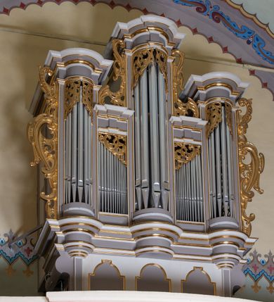 Zdjęcie nr 28: Kościół jest jednonawowy, trójprzęsłowy, z płytkimi kaplicami tworzącymi pseudotransept i jednoprzęsłowym prezbiterium zakończonym apsydą. Do prezbiterium przylegają dwa aneksy mieszące w przyziemiu zakrystię i skarbczyk, a na piętrze empory otwarte na prezbiterium. Do nawy od południa dostawiona jest kruchta. W naroża między kaplicami a nawą wstawiono dwie wieże-dzwonnice z klatkami schodowymi prowadzącymi na empory. Nawa jest rozczłonkowana płaskimi, szerokimi pilastrami toskańskimi, a nakryta sklepieniem kolebkowym z lunetami; prezbiterium przykryte sklepieniem kolebkowym z żebrami spływającymi na wsporniki, apsyda sklepieniem parasolowatym.  Prezbiterium ujęte dwiema głębokimi, półkoliście zamkniętymi wnękami, nad którymi parapety empor z ślepymi arkadkami z balasów jenolalkowych i łuków półkolistych. Wnętrze oświetlają wysokie i szerokie okna zamknięte półkoliście. W aneksach przy prezbiterium i w emporach znajdują się okna prostokątne. Fasada dwustrefowa, trójosiowa, ale osie i strefy wyznaczone jedynie przez okna, drzwi i nisze, zamknięta trójkątnie.    
Portal prostokątnych drzwi utworzony z pary żłobkowanych, toskańskich pilastrów, podtrzymujących belkowanie z trójkątnym przyczółkiem. Fryz belkowania ozdobiony tryglifami z łezkami i metopami w kształcie rozet i talerzy, a przyczółek kostkowaniem. Nad portalem okno w głębokim rozglifieniu, w kształcie prostokąta zamkniętego półkoliście. Po bokach portalu i okna głębokie nisze ujęte od dołu i góry odcinkami gzymsu. Zewnętrzne elewacje ujęte częściowo szkarpami, częściowo lizenami. W wieżach wejścia do kościoła i na klatki schodowe oraz niewielkie okienka w klatce schodowej i prześwity zamknięte półkoliście w dzwonnicach. Dachy dwuspadowe, na wieżach czterospadowe, nad nawą, wieżami i aneksami przy prezbiterium kryte dachówką, nad prezbiterium blachą. Na dachu wieżyczka na sygnaturkę. 
