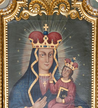 Zdjęcie nr 5: Obraz w kształcie stojącego prostokąta zamkniętego półkolistym łukiem nadwieszonym, uskokowym. Madonna w typie Hodegetrii została przedstawiona frontalnie, w półpostaci. Głowę ma lekko zwróconą w lewo, twarz owalną, o prostych rysach, jasnej karnacji, długim, wąskim nosie, dużych oczach w jasnej oprawie i drobnych ustach. Na prawym policzku dwa równoległe, ukośnie biegnące nacięcia. Maria ubrana jest w jasnoczerwoną suknię ze złoconym galonem pod szyją oraz dekorowany wzorami floralnymi ciemnoniebieski płaszcz ze złotą lamówką osłaniający głowę, ręce i korpus. Na szyi ma zawieszony podwójny sznur pereł ze złotym krzyżykiem, na głowie złotą koronę w typie otwartym, wysadzaną kamieniami szlachetnymi, z czerwonym wypełnieniem. Prawą ręką wskazuje na trzymane na lewej ręce siedzące Dzieciątko. Jezus jest zwrócony w trzech czwartych w prawo. Głowę ma lekko odchyloną na lewy bark, twarz owalną, o jasnej cerze i delikatnych rysach. Długie, brązowe, falowane włosy opadają mu na ramiona i plecy. Jest ubrany w czerwoną tunikę z wąskimi rękawami i złotymi obszyciami. Na głowie ma koronę w typie otwartym, wysadzaną szlachetnymi kamieniami z czerwonym wypełnieniem. Lewą ręką podtrzymuje księgę w oprawie ze złotym napisem IHS i zapięciami, prawą unosi w geście błogosławieństwa. Wokół głów postaci promieniste nimby i gwiazdki. Tło jednolite, szare. W górnej partii obrazu płaskorzeźbiony, ażurowy ornament stylizowanej wici roślinnej z okiem opatrzności Bożej w promienistej glorii pośrodku. Kolorystyka intensywna, mocne kontrasty kolorystyczne. Obraz ujęty złoconą, profilowaną ramą. 
