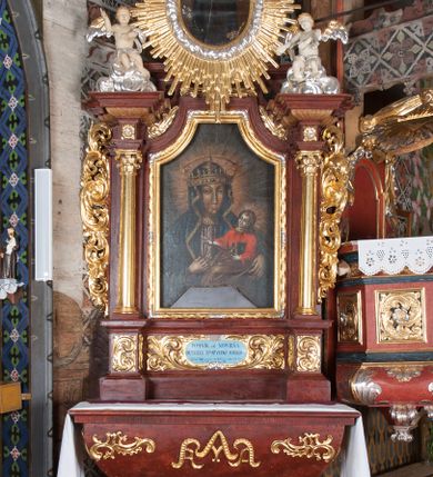 Zdjęcie nr 2: Ołtarz przyścienny, architektoniczny, jednokondygnacyjny, jednoosiowy, ze zwieńczeniem. Mensa w typie sarkofagowym z kamiennym portatylem, dekorowana w dolnej partii srebrnymi liśćmi akantu, a w górnej pośrodku płaskorzeźbiony monogram maryjny ujęty plakietami ornamentalnymi z kształtów nawiązujących do motywu rocaille’a; całość mensy groszkowana. Retabulum na cokole o wysuniętych bokach, ujęte parą kolumn o kapitelach akantowych i gładkich trzonach, wspierających fragmenty belkowania z silnie wysuniętymi fryzem i gzymsem. Pola cokołu retabulum zdobione motywem wici akantowej, z kartuszem w kształcie leżącego owalu pośrodku z ciemnoniebieskim napisem na jasnoniebieskim tle „POMŃIK od NOWIEŃA / OŁTARZA ZPOŻYCZKI HARKLOwy / dodał Utrzymańie przy tej Robocie Stanisław Plewa. / w. 1856”. Oś środkową nastawy wypełnia pole w kształcie stojącego prostokąta o wklęsłych górnych narożach, ujęte profilowaną, częściowo złoconą ramą, z motywem liści laurowych. W polu obraz z przedstawieniem Madonny z Dzieciątkiem. Kondygnację flankują ażurowe uszaki utworzone z bujnej, mięsistej wici akantu. Zwieńczenie tworzy owalne przedstawienie św. Kingi otoczone srebrnymi obłokami oraz glorią promienistą o promieniach różnej długości. Zwieńczenie flankuje para nagich aniołków posadowionych na srebrzonych chmurach, umieszczonych na fragmentach belkowania retabulum. 
Struktura polichromowana w kolorze brązowym. Partie detalu architektonicznego i ornamentyka złocone i srebrzone. 
