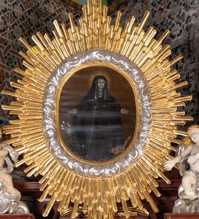 Zdjęcie nr 10: Ołtarz przyścienny, architektoniczny, jednokondygnacyjny, jednoosiowy, ze zwieńczeniem. Mensa w typie sarkofagowym z kamiennym portatylem, dekorowana w dolnej partii srebrnymi liśćmi akantu, a w górnej pośrodku płaskorzeźbiony monogram maryjny ujęty plakietami ornamentalnymi z kształtów nawiązujących do motywu rocaille’a; całość mensy groszkowana. Retabulum na cokole o wysuniętych bokach, ujęte parą kolumn o kapitelach akantowych i gładkich trzonach, wspierających fragmenty belkowania z silnie wysuniętymi fryzem i gzymsem. Pola cokołu retabulum zdobione motywem wici akantowej, z kartuszem w kształcie leżącego owalu pośrodku z ciemnoniebieskim napisem na jasnoniebieskim tle „POMŃIK od NOWIEŃA / OŁTARZA ZPOŻYCZKI HARKLOwy / dodał Utrzymańie przy tej Robocie Stanisław Plewa. / w. 1856”. Oś środkową nastawy wypełnia pole w kształcie stojącego prostokąta o wklęsłych górnych narożach, ujęte profilowaną, częściowo złoconą ramą, z motywem liści laurowych. W polu obraz z przedstawieniem Madonny z Dzieciątkiem. Kondygnację flankują ażurowe uszaki utworzone z bujnej, mięsistej wici akantu. Zwieńczenie tworzy owalne przedstawienie św. Kingi otoczone srebrnymi obłokami oraz glorią promienistą o promieniach różnej długości. Zwieńczenie flankuje para nagich aniołków posadowionych na srebrzonych chmurach, umieszczonych na fragmentach belkowania retabulum. 
Struktura polichromowana w kolorze brązowym. Partie detalu architektonicznego i ornamentyka złocone i srebrzone. 
