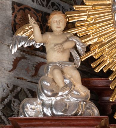 Zdjęcie nr 3: Ołtarz przyścienny, architektoniczny, jednokondygnacyjny, jednoosiowy, ze zwieńczeniem. Mensa w typie sarkofagowym z kamiennym portatylem, dekorowana w dolnej partii srebrnymi liśćmi akantu, a w górnej pośrodku płaskorzeźbiony monogram maryjny ujęty plakietami ornamentalnymi z kształtów nawiązujących do motywu rocaille’a; całość mensy groszkowana. Retabulum na cokole o wysuniętych bokach, ujęte parą kolumn o kapitelach akantowych i gładkich trzonach, wspierających fragmenty belkowania z silnie wysuniętymi fryzem i gzymsem. Pola cokołu retabulum zdobione motywem wici akantowej, z kartuszem w kształcie leżącego owalu pośrodku z ciemnoniebieskim napisem na jasnoniebieskim tle „POMŃIK od NOWIEŃA / OŁTARZA ZPOŻYCZKI HARKLOwy / dodał Utrzymańie przy tej Robocie Stanisław Plewa. / w. 1856”. Oś środkową nastawy wypełnia pole w kształcie stojącego prostokąta o wklęsłych górnych narożach, ujęte profilowaną, częściowo złoconą ramą, z motywem liści laurowych. W polu obraz z przedstawieniem Madonny z Dzieciątkiem. Kondygnację flankują ażurowe uszaki utworzone z bujnej, mięsistej wici akantu. Zwieńczenie tworzy owalne przedstawienie św. Kingi otoczone srebrnymi obłokami oraz glorią promienistą o promieniach różnej długości. Zwieńczenie flankuje para nagich aniołków posadowionych na srebrzonych chmurach, umieszczonych na fragmentach belkowania retabulum. 
Struktura polichromowana w kolorze brązowym. Partie detalu architektonicznego i ornamentyka złocone i srebrzone. 
