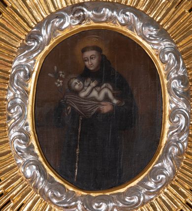 Zdjęcie nr 12: Ołtarz przyścienny, architektoniczny, jednokondygnacyjny, jednoosiowy, ze zwieńczeniem. Mensa w typie sarkofagowym z kamiennym portatylem, dekorowana w dolnej partii srebrnymi liśćmi akantu, a w górnej plakietą w kształcie leżącego prostokąta o zaokrąglonych narożach przenikającego owal; kształt wypełniają odchodzące od centralnego pola złote promienie. Ujmują je plakiety ornamentalne z kształtów nawiązujących do motywu rocaille’a; całość mensy groszkowana. Retabulum na cokole o wysuniętych bokach, ujęte parą kolumn o kapitelach akantowych i trzonach zdobionych żłobkowaniem od frontu, wspierających fragmenty belkowania z silnie wysuniętymi fryzem i gzymsem. Pola cokołu retabulum zdobione motywem wici akantowej ujmującej jasnoniebieski kartusz w kształcie leżącego owalu przenikającego się ze stojącym prostokątem. Oś środkową nastawy wypełnia pole w kształcie stojącego prostokąta o wklęsłych górnych narożach, ujęte profilowaną, częściowo złoconą ramą, z motywem liści laurowych. W środku wizerunek ukrzyżowanego Jezusa na tle lustra. Na zasuwie obraz św. Teresy od Dzieciątka Jezus. Kondygnację flankują ażurowe uszaki utworzone z bujnej, mięsistej wici z liści akantu. Zwieńczenie tworzy owalne przedstawienie św. Antoniego Padewskiego otoczone srebrnymi obłokami oraz glorią promienistą o promieniach różnej długości. Zwieńczenie flankuje para nagich aniołków posadowionych na srebrzonych chmurach, umieszczonych na fragmentach belkowania retabulum. 
Struktura polichromowana w kolorze brązowym. Partie detalu architektonicznego i ornamentyka złocone i srebrzone. 
