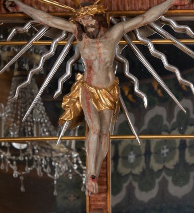 Zdjęcie nr 16: Ołtarz przyścienny, architektoniczny, jednokondygnacyjny, jednoosiowy, ze zwieńczeniem. Mensa w typie sarkofagowym z kamiennym portatylem, dekorowana w dolnej partii srebrnymi liśćmi akantu, a w górnej plakietą w kształcie leżącego prostokąta o zaokrąglonych narożach przenikającego owal; kształt wypełniają odchodzące od centralnego pola złote promienie. Ujmują je plakiety ornamentalne z kształtów nawiązujących do motywu rocaille’a; całość mensy groszkowana. Retabulum na cokole o wysuniętych bokach, ujęte parą kolumn o kapitelach akantowych i trzonach zdobionych żłobkowaniem od frontu, wspierających fragmenty belkowania z silnie wysuniętymi fryzem i gzymsem. Pola cokołu retabulum zdobione motywem wici akantowej ujmującej jasnoniebieski kartusz w kształcie leżącego owalu przenikającego się ze stojącym prostokątem. Oś środkową nastawy wypełnia pole w kształcie stojącego prostokąta o wklęsłych górnych narożach, ujęte profilowaną, częściowo złoconą ramą, z motywem liści laurowych. W środku wizerunek ukrzyżowanego Jezusa na tle lustra. Na zasuwie obraz św. Teresy od Dzieciątka Jezus. Kondygnację flankują ażurowe uszaki utworzone z bujnej, mięsistej wici z liści akantu. Zwieńczenie tworzy owalne przedstawienie św. Antoniego Padewskiego otoczone srebrnymi obłokami oraz glorią promienistą o promieniach różnej długości. Zwieńczenie flankuje para nagich aniołków posadowionych na srebrzonych chmurach, umieszczonych na fragmentach belkowania retabulum. 
Struktura polichromowana w kolorze brązowym. Partie detalu architektonicznego i ornamentyka złocone i srebrzone. 
