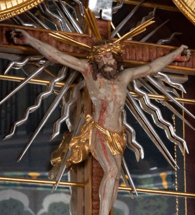 Zdjęcie nr 3: Ołtarz przyścienny, architektoniczny, jednokondygnacyjny, jednoosiowy, ze zwieńczeniem. Mensa w typie sarkofagowym z kamiennym portatylem, dekorowana w dolnej partii srebrnymi liśćmi akantu, a w górnej plakietą w kształcie leżącego prostokąta o zaokrąglonych narożach przenikającego owal; kształt wypełniają odchodzące od centralnego pola złote promienie. Ujmują je plakiety ornamentalne z kształtów nawiązujących do motywu rocaille’a; całość mensy groszkowana. Retabulum na cokole o wysuniętych bokach, ujęte parą kolumn o kapitelach akantowych i trzonach zdobionych żłobkowaniem od frontu, wspierających fragmenty belkowania z silnie wysuniętymi fryzem i gzymsem. Pola cokołu retabulum zdobione motywem wici akantowej ujmującej jasnoniebieski kartusz w kształcie leżącego owalu przenikającego się ze stojącym prostokątem. Oś środkową nastawy wypełnia pole w kształcie stojącego prostokąta o wklęsłych górnych narożach, ujęte profilowaną, częściowo złoconą ramą, z motywem liści laurowych. W środku wizerunek ukrzyżowanego Jezusa na tle lustra. Na zasuwie obraz św. Teresy od Dzieciątka Jezus. Kondygnację flankują ażurowe uszaki utworzone z bujnej, mięsistej wici z liści akantu. Zwieńczenie tworzy owalne przedstawienie św. Antoniego Padewskiego otoczone srebrnymi obłokami oraz glorią promienistą o promieniach różnej długości. Zwieńczenie flankuje para nagich aniołków posadowionych na srebrzonych chmurach, umieszczonych na fragmentach belkowania retabulum. 
Struktura polichromowana w kolorze brązowym. Partie detalu architektonicznego i ornamentyka złocone i srebrzone. 
