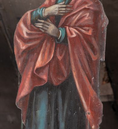 Zdjęcie nr 8: Chrystus rozpięty na krzyżu z szeroko rozłożonymi rękami, w lekkim zwisie ciała, z lekko ugiętymi kolanami i stopami założonymi prawa na lewą, przybitymi jednym gwoździem. Głowa pochylona na prawy bark. Twarz pociągła z długim nosem i wydatnymi kośćmi policzkowymi, okolona długimi ciemnymi włosami i zarostem. Ciało muskularne o ciemnej karnacji z zaznaczonymi śladami męki. Wokół bioder złocone perizonium podtrzymywane sznurem, ze zwisem draperii wzdłuż prawego uda. Matka Boska Bolesna ukazana w całej postaci, w ujęciu w trzech czwartych, zwrócona w lewo w kierunku krzyża; stoi w kontrapoście z głową przechyloną w lewo. Ręce ugięte w łokciach, dłonie skrzyżowane w przegubach ułożone na wysokości piersi. Ubrana w długą fałdzistą czerwoną suknię i narzucony na ramiona ciemnoniebieski płaszcz. Na głowie i ramionach biała chusta; wokół głowy nimb. Św. Jan Ewangelista przedstawiony w całej postaci, w ujęciu w trzech czwartych, zwrócony w prawo w kierunku krzyża.  Twarz o młodzieńczych rysach (bez zarostu), widoczna z profilu, zwrócona ku górze, ku Chrystusowi. Ręce ugięte w łokciach, z dłońmi złożonymi na piersiach na różnej wysokości. Ubrany w długą ciemnoniebieską suknię i czerwony płaszcz. Wokół głowy nimb.   