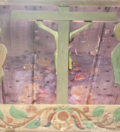 Zdjęcie nr 5: Chrystus rozpięty na krzyżu z szeroko rozłożonymi rękami, w lekkim zwisie ciała, z lekko ugiętymi kolanami i stopami założonymi prawa na lewą, przybitymi jednym gwoździem. Głowa pochylona na prawy bark. Twarz pociągła z długim nosem i wydatnymi kośćmi policzkowymi, okolona długimi ciemnymi włosami i zarostem. Ciało muskularne o ciemnej karnacji z zaznaczonymi śladami męki. Wokół bioder złocone perizonium podtrzymywane sznurem, ze zwisem draperii wzdłuż prawego uda. Matka Boska Bolesna ukazana w całej postaci, w ujęciu w trzech czwartych, zwrócona w lewo w kierunku krzyża; stoi w kontrapoście z głową przechyloną w lewo. Ręce ugięte w łokciach, dłonie skrzyżowane w przegubach ułożone na wysokości piersi. Ubrana w długą fałdzistą czerwoną suknię i narzucony na ramiona ciemnoniebieski płaszcz. Na głowie i ramionach biała chusta; wokół głowy nimb. Św. Jan Ewangelista przedstawiony w całej postaci, w ujęciu w trzech czwartych, zwrócony w prawo w kierunku krzyża.  Twarz o młodzieńczych rysach (bez zarostu), widoczna z profilu, zwrócona ku górze, ku Chrystusowi. Ręce ugięte w łokciach, z dłońmi złożonymi na piersiach na różnej wysokości. Ubrany w długą ciemnoniebieską suknię i czerwony płaszcz. Wokół głowy nimb.   