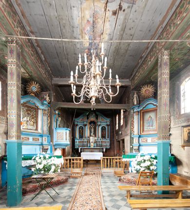 Zdjęcie nr 27: Kościół orientowany, nawa prostokątna, z węższym, zamkniętym wielobocznie prezbiterium, przy którym zakrystia od północy i kaplica od południa. Przy nawie od zachodu wieża na rzucie kwadratu, z aneksami bocznymi, zwieńczona izbicą z hełmem. Wewnątrz stropy, w nawie z zaskrzynieniami wspartymi na słupach. Dach naw nawą i prezbiterium wspólny, dwuspadowy, nad kaplicą pulpitowy.