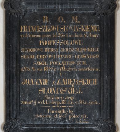 Zdjęcie nr 2: Tablica w kształcie stojącego prostokąta, w szerokiej, profilowanej ramie, z narożami ujętymi muszlami palmetowymi na tle liści akantu z palmetami. Inskrypcja: „D(EO) O(PTIMO) M(AXIMO) / FRANCISZKOWI SŁONINSKIEMU. / wysłużonemu przez lat 26. w Lice(um) Krak(owskim) S(więtej) Anny / PROFESSOROWI. / SENIOROWI BURSY JEROZOLIMSKIEJ, / SEKRETARZOWI DOZORU GŁÓWNEGO / SZKÓŁ POCZĄTKOWYCH. / d(nia) 23 Marca 1847 r(oku) w 79. r(oku) życia zmarłemu. / i / JOANNIE z ZADĘBSKICH / SŁONIŃSKIEJ. / Małżonce Jego, / zmarłej w d(niu) 1. Sierp(nia) 1831. r(oku) w 56. r(oku) życia. / Pamiątkę tę / wdzięczne dzieci położyły”. W prawym dolnym rogu sygnatura: „Sc(ulpsit) T. Kuhn”. 
