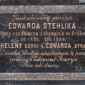 Zdjęcie nr 1: Epitafium o formie leżącego prostokąta z uszakami. Pole z inskrypcją gładkie, prostokątne, z ćwierćkoliście ściętymi rogami, obwiedzione pasem z surowego, nie polerowanego marmuru. W polu inskrypcja „Nieodżałowanej pamięci / EDWARDA STEHLIKA / artysty rzeźbiarza i obywatela m(iasta) Krakowa / ur(odzonego) 1835. zm(arłego) 1888.  / HELENY CÓRKI i EDWARDA SYNA / żona i matka kładzie ukochanym tę pamiątkę / prosząc o Zdrowaś Marya / za ich duszę.”
  
