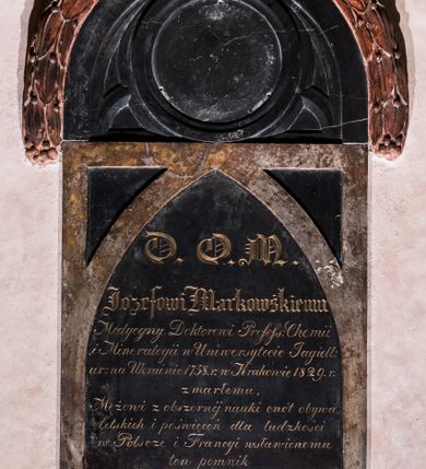 Zdjęcie nr 1: Epitafium wsparte na dwóch konsolach, podtrzymujących gzyms, nad którym dwie płyty: dolna prostokątna, z wydzieloną ostrołukowo zakończoną tablicą z inskrypcją oraz górna, półkolista, w formie maswerku, z okrągłym polem na portret i wieńcem laurowym wzdłuż górnej krawędzi, zwieńczonym krzyżem. Inskrypcja „D(EO) O(PTIMO) M(AXIMO) / Jozefowi Markowskiemu / Medycyny Doktorowi Profess(orowi) Chemii / i Mineralogii w Uniwersytecie Jagiell(ońskim) / ur(odzonemu) na Ukrainie 1758 r(oku) w Krakowie 1829 r(oku) / zmarłemu / Mężowi z obszernej nauki cnót obywa/telskich i poświęceń dla ludzkości / w Polscze i Francyi wsławionemu / ten pomnik / Marya z Langlotów Markowska / położyła.” 
