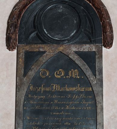Zdjęcie nr 2: Epitafium wsparte na dwóch konsolach, podtrzymujących gzyms, nad którym dwie płyty: dolna prostokątna, z wydzieloną ostrołukowo zakończoną tablicą z inskrypcją oraz górna, półkolista, w formie maswerku, z okrągłym polem na portret i wieńcem laurowym wzdłuż górnej krawędzi, zwieńczonym krzyżem. Inskrypcja „D(EO) O(PTIMO) M(AXIMO) / Jozefowi Markowskiemu / Medycyny Doktorowi Profess(orowi) Chemii / i Mineralogii w Uniwersytecie Jagiell(ońskim) / ur(odzonemu) na Ukrainie 1758 r(oku) w Krakowie 1829 r(oku) / zmarłemu / Mężowi z obszernej nauki cnót obywa/telskich i poświęceń dla ludzkości / w Polscze i Francyi wsławionemu / ten pomnik / Marya z Langlotów Markowska / położyła.” 
