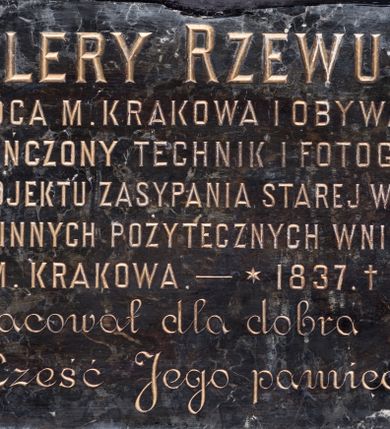 Zdjęcie nr 1: Tablica w kształcie leżącego prostokąta z inskrypcją „WALERY RZEWUSKI / RADCA M(IASTA) KRAKOWA I OBYWATEL / UKOŃCZONY TECHNIK I FOTOGRAF / AUTOR PROJEKTU ZASYPANIA STAREJ WISŁY 1871 R[OKU] / I WIELU INNYCH POŻYTECZNYCH WNIOSKÓW / DLA M(IASTA) KRAKOWA. – *1837. + 1888. / Żył i pracował dla dobra miasta / Cześć Jego pamięci!”