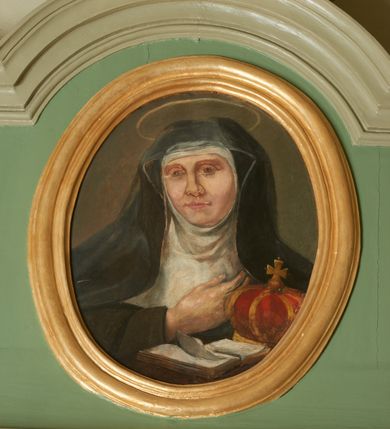 Zdjęcie nr 2: Portal drzwi prostokątnych, prowadzących do kaplicy zakonnej, dwuskrzydłowych, czteropolowych, z romboidalnymi występami został ujęty ukośnie dostawionymi pilastrami z konsolami w miejscu głowic, podtrzymującymi profilowany, mocno wysunięty gzyms. Górna część jest flankowana spływami wolutowymi z kampanulami, zakończonymi rokokowymi wazonami i jest zwieńczona profilowanym gzymsem w kształcie łuku nadwieszonego. W zwieńczeniu owalny obraz w profilowanej, złoconej ramie z wizerunkiem św. Kingi. 
