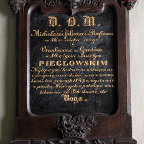Zdjęcie nr 1: Epitafium utworzone z cokołu, tablicy inskrypcyjnej i dwóch okrągłych portretów zwieńczonych krzyżem. Cokół z czterema arkadkami pod nim i dwiema tarczami z godłami herbów Nałęcz i Rawicz zwieńczonymi koroną. Nad nią klejnot herbu Nałęcz (kobieta z przepaską na czole trzymająca w rękach rogi jelenia) oraz obok niego litery „B. G”. Na tablicy inskrypcja: „D(EO) O(PTIMO) M(AXIMO) / Michałowi Felixowi z Piegłowa / w 86. r(oku) wieku swego / i / Barbarze z Grotów / w 80. r(oku) życia zmarłym / PIEGŁOWSKIM / Najlepszym Rodzicom wdzięczne / i przywiązane dzieci wraz z wnu/kami ten pomnik 1847. r(oku) wystawili / z prośbą Wiernych o pobożne wes/tchnienie za Ich dusze do / Boga”. Nad tablicą okrągłe obrazy z portretami zmarłych, ukazanych w popiersiu. Kobieta o starczej twarzy, długim nosie, otwartych migdałowatych oczach i zaciśniętych ustach, czarnych włosach okrytych prześwitującym czepcem. Ubrana jest w niebieską suknię z niewielkim dekoltem i koronkowym kołnierzem. Mężczyzna ukazany w trzech czwartych, zwrócony w prawo, o wyrazistej twarzy, z długim nosem, otwartymi oczami, zaciśniętymi ustami i z krótkimi brązowymi włosami. Ubrany jest w białą koszulę z wysokim kołnierzem z żabotem oraz czarny płaszcz. Portrety osadzone w profilowanych ramach spiętych od góry łukiem w kształcie oślego grzbietu z żabkami, zwieńczonym krzyżem o ramionach zakończonych stylizowanym astwerkiem.          




