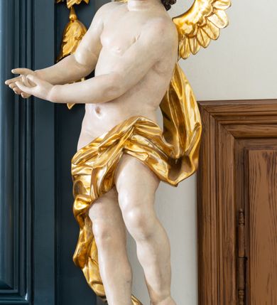 Zdjęcie nr 6: Ołtarz drewniany, jednoosiowy, jednokondygnacyjny. Mensa ołtarza z antepedium, w którym złocony krzyż. Nastawa ujęta postumentami z aniołami, w profilowanej ramie z kampanulami po bokach, z uszkami i konsolami w górnej części, zwieńczona bogato profilowanym wklęsłym gzymsem przechodzącym w dwie zwrócone ku sobie woluty z kartuszem i godłem Kotwica, umieszczonym pod muszlą palmetową. Obraz w ramie profilowanej, prostokątny, zamknięty półkolistym łukiem nadwieszonym. Stojące po bokach aniołki ukazane w kontrapoście, nagie, o pulchnych kształtach, przepasane na biodrach, z zarzuconymi na plecy złoconymi, miękko marszczonymi draperiami. Nastawa ciemnozielona ze złoconymi ornamentami i profilami; aniołki w naturalistycznej tonacji kolorystycznej. 
