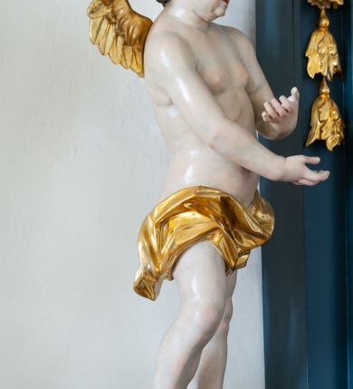 Zdjęcie nr 5: Ołtarz drewniany, jednoosiowy, jednokondygnacyjny. Mensa ołtarza z antepedium, w którym złocony krzyż. Nastawa ujęta postumentami z aniołami, w profilowanej ramie z kampanulami po bokach, z uszkami i konsolami w górnej części, zwieńczona bogato profilowanym wklęsłym gzymsem przechodzącym w dwie zwrócone ku sobie woluty z kartuszem i godłem Kotwica, umieszczonym pod muszlą palmetową. Obraz w ramie profilowanej, prostokątny, zamknięty półkolistym łukiem nadwieszonym. Stojące po bokach aniołki ukazane w kontrapoście, nagie, o pulchnych kształtach, przepasane na biodrach, z zarzuconymi na plecy złoconymi, miękko marszczonymi draperiami. Nastawa ciemnozielona ze złoconymi ornamentami i profilami; aniołki w naturalistycznej tonacji kolorystycznej. 
