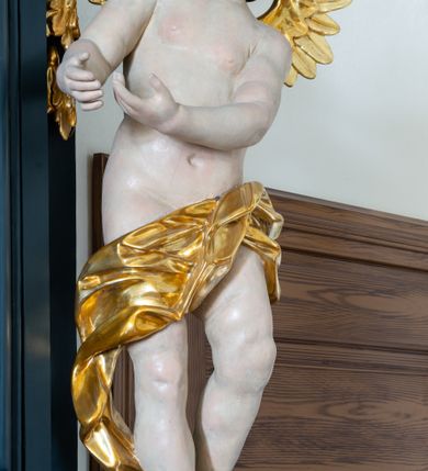 Zdjęcie nr 9: Ołtarz drewniany, jednoosiowy, jednokondygnacyjny. Mensa ołtarza z antepedium, w którym złocony krzyż. Nastawa ujęta postumentami z aniołami, w profilowanej ramie z kampanulami po bokach, z uszkami i konsolami w górnej części, zwieńczona bogato profilowanym wklęsłym gzymsem przechodzącym w dwie zwrócone ku sobie woluty z kartuszem i godłem Kotwica, umieszczonym pod muszlą palmetową. Obraz w ramie profilowanej, prostokątny, zamknięty półkolistym łukiem nadwieszonym. Stojące po bokach aniołki ukazane w kontrapoście, nagie, o pulchnych kształtach, przepasane na biodrach, z zarzuconymi na plecy złoconymi, miękko marszczonymi draperiami. Nastawa ciemnozielona ze złoconymi ornamentami i profilami; aniołki w naturalistycznej tonacji kolorystycznej. 
