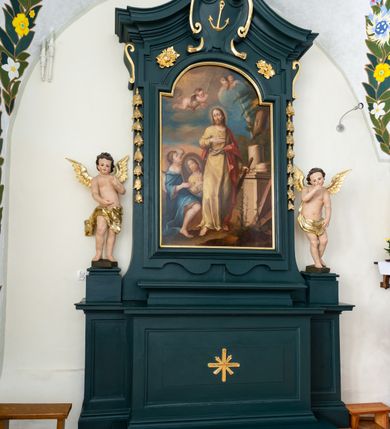 Zdjęcie nr 3: Ołtarz drewniany, jednoosiowy, jednokondygnacyjny. Mensa ołtarza z antepedium, w którym złocony krzyż. Nastawa ujęta postumentami z aniołami, w profilowanej ramie z kampanulami po bokach, z uszkami i konsolami w górnej części, zwieńczona bogato profilowanym wklęsłym gzymsem przechodzącym w dwie zwrócone ku sobie woluty z kartuszem i godłem Kotwica, umieszczonym pod muszlą palmetową. Obraz w ramie profilowanej, prostokątny, zamknięty półkolistym łukiem nadwieszonym. Stojące po bokach aniołki ukazane w kontrapoście, nagie, o pulchnych kształtach, przepasane na biodrach, z zarzuconymi na plecy złoconymi, miękko marszczonymi draperiami. Nastawa ciemnozielona ze złoconymi ornamentami i profilami; aniołki w naturalistycznej tonacji kolorystycznej. 
