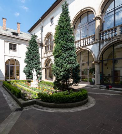 Zdjęcie nr 6: Kościół jest murowany z cegły, tynkowany, jednonawowy. Założony jest na rzucie prostokąta, z czteroprzęsłowym korpusem oraz jednoprzęsłowym prezbiterium, zamknięty prosto i skierowanym na południe. Ściana południowa wychodzi na ogród klasztorny, natomiast wschodnia i północna złączone są z klasztorem. Prezbiterium po obu stronach flankowane jest zakrystiami, nad którymi mieszczą się małe chóry. Chóry otwierają się do pojedynczymi arkadami do prezbiterium z drewnianymi balustradami. Do dwuprzęsłowej nawy od północy przylegają kolejne dwa przęsła korpusu, które stanowią kruchtę i kaplicę klasztoru, a nad nimi wzniesiony jest chór zakonny, oddzielony kratą. Nawa artykułowana jest za pomocą zdwojonych filarów, dźwigających wydatne belkowanie i tworzących półkoliście zamknięte wnęki arkadowe na ołtarze. Korpus kościoła sklepiony jest kolebkowo z lunetami na gurtach, natomiast w prezbiterium i kruchcie znajdują się sklepienia krzyżowe. Ściana arkady tęczowej zamknięta jest półkoliście. Wnętrze kościoła doświetlają umieszczone ponad belkowaniem okna w kształcie stojących prostokątów, zamknięte półkoliście. Do kościoła prowadzą drzwi wejściowe od północy przez kruchtę, do której wejście znajduje się od zachodu przez dziedziniec. Kolejne dwa wejścia prowadzą od strony klasztory przez kruchtę i zakrystię. Fasada północna kościoła wtopiona jest w bryłę klasztoru. Od strony dziedzińca, prowadzącego do głównego wejścia widoczna jest strona zachodnia kościoła, artykułowa zdwojonymi pilastrami. Portal główny flankowany jest kolumnami na tle pilastrów, które podtrzymują belkowanie i przerwany półkoliście zamknięty przyczółek. Podpory wsparte są na wysokich cokołach. Drzwi wejściowe flankuje półkoliście zamknięta arkada wsparta na parze filarów. Kościół nakrywa dach siodłowy, nad drugim przęsłem korpusu od strony północnej znajduje się wieżyczka na sygnaturkę ze zdwojoną latarnią. Przed kościołem znajduje się dziedziniec oddzielony od ulicy klasycystycznym murem z bramą.