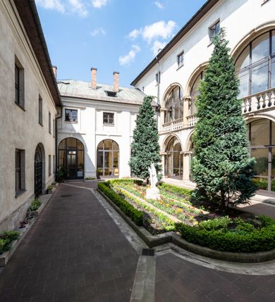 Zdjęcie nr 5: Kościół jest murowany z cegły, tynkowany, jednonawowy. Założony jest na rzucie prostokąta, z czteroprzęsłowym korpusem oraz jednoprzęsłowym prezbiterium, zamknięty prosto i skierowanym na południe. Ściana południowa wychodzi na ogród klasztorny, natomiast wschodnia i północna złączone są z klasztorem. Prezbiterium po obu stronach flankowane jest zakrystiami, nad którymi mieszczą się małe chóry. Chóry otwierają się do pojedynczymi arkadami do prezbiterium z drewnianymi balustradami. Do dwuprzęsłowej nawy od północy przylegają kolejne dwa przęsła korpusu, które stanowią kruchtę i kaplicę klasztoru, a nad nimi wzniesiony jest chór zakonny, oddzielony kratą. Nawa artykułowana jest za pomocą zdwojonych filarów, dźwigających wydatne belkowanie i tworzących półkoliście zamknięte wnęki arkadowe na ołtarze. Korpus kościoła sklepiony jest kolebkowo z lunetami na gurtach, natomiast w prezbiterium i kruchcie znajdują się sklepienia krzyżowe. Ściana arkady tęczowej zamknięta jest półkoliście. Wnętrze kościoła doświetlają umieszczone ponad belkowaniem okna w kształcie stojących prostokątów, zamknięte półkoliście. Do kościoła prowadzą drzwi wejściowe od północy przez kruchtę, do której wejście znajduje się od zachodu przez dziedziniec. Kolejne dwa wejścia prowadzą od strony klasztory przez kruchtę i zakrystię. Fasada północna kościoła wtopiona jest w bryłę klasztoru. Od strony dziedzińca, prowadzącego do głównego wejścia widoczna jest strona zachodnia kościoła, artykułowa zdwojonymi pilastrami. Portal główny flankowany jest kolumnami na tle pilastrów, które podtrzymują belkowanie i przerwany półkoliście zamknięty przyczółek. Podpory wsparte są na wysokich cokołach. Drzwi wejściowe flankuje półkoliście zamknięta arkada wsparta na parze filarów. Kościół nakrywa dach siodłowy, nad drugim przęsłem korpusu od strony północnej znajduje się wieżyczka na sygnaturkę ze zdwojoną latarnią. Przed kościołem znajduje się dziedziniec oddzielony od ulicy klasycystycznym murem z bramą.