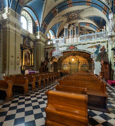 Zdjęcie nr 22: Kościół jest murowany z cegły, tynkowany, jednonawowy. Założony jest na rzucie prostokąta, z czteroprzęsłowym korpusem oraz jednoprzęsłowym prezbiterium, zamknięty prosto i skierowanym na południe. Ściana południowa wychodzi na ogród klasztorny, natomiast wschodnia i północna złączone są z klasztorem. Prezbiterium po obu stronach flankowane jest zakrystiami, nad którymi mieszczą się małe chóry. Chóry otwierają się do pojedynczymi arkadami do prezbiterium z drewnianymi balustradami. Do dwuprzęsłowej nawy od północy przylegają kolejne dwa przęsła korpusu, które stanowią kruchtę i kaplicę klasztoru, a nad nimi wzniesiony jest chór zakonny, oddzielony kratą. Nawa artykułowana jest za pomocą zdwojonych filarów, dźwigających wydatne belkowanie i tworzących półkoliście zamknięte wnęki arkadowe na ołtarze. Korpus kościoła sklepiony jest kolebkowo z lunetami na gurtach, natomiast w prezbiterium i kruchcie znajdują się sklepienia krzyżowe. Ściana arkady tęczowej zamknięta jest półkoliście. Wnętrze kościoła doświetlają umieszczone ponad belkowaniem okna w kształcie stojących prostokątów, zamknięte półkoliście. Do kościoła prowadzą drzwi wejściowe od północy przez kruchtę, do której wejście znajduje się od zachodu przez dziedziniec. Kolejne dwa wejścia prowadzą od strony klasztory przez kruchtę i zakrystię. Fasada północna kościoła wtopiona jest w bryłę klasztoru. Od strony dziedzińca, prowadzącego do głównego wejścia widoczna jest strona zachodnia kościoła, artykułowa zdwojonymi pilastrami. Portal główny flankowany jest kolumnami na tle pilastrów, które podtrzymują belkowanie i przerwany półkoliście zamknięty przyczółek. Podpory wsparte są na wysokich cokołach. Drzwi wejściowe flankuje półkoliście zamknięta arkada wsparta na parze filarów. Kościół nakrywa dach siodłowy, nad drugim przęsłem korpusu od strony północnej znajduje się wieżyczka na sygnaturkę ze zdwojoną latarnią. Przed kościołem znajduje się dziedziniec oddzielony od ulicy klasycystycznym murem z bramą.