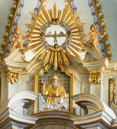 Zdjęcie nr 5: Nastawa ołtarzowa architektoniczna, jednoosiowa, dwukondygnacyjna ze zwieńczeniem. Mensa sarkofagowa, na niej tabernakulum w kształcie prostopadłościennej skrzynki na profilowanym cokole. Drzwiczki w formie stojącego prostokąta dekorowanego kielichem z hostią w glorii adorowaną przez klęczące anioły. Na nim ustawiono krucyfiks. Nastawa ołtarzowa na cokole, flankowana parami kolumn kompozytowych na tle pilastrów. Wewnętrzne kolumny ustawiono ukosem do wewnątrz, zewnętrzne na zewnątrz. Podpory  dźwigają fragmenty rozbudowanego belkowania o różnym wykroju ponad nimi i uwypuklającego się ponad polem centralnym. Wypełnia je nisza w kształcie stojącego prostokąta z uszakami, zamkniętego od góry łukiem nadwieszonym z uskokami. W niej znajduje się obraz z przedstawieniem św. Marcina w profilowanej, złoconej ramie.  Wewnętrzne podpory dźwigają fragmenty przerwanego przyczółka. Druga kondygnacja ma półokrągły wykrój, jest flankowana zwielokrotnionymi pilastrami   dekorowanymi płonącym rocaille’m i podtrzymującymi niewielkie spływy wolutowe, na których usadowiono putta. Pilastry ujmują spływy opierające się na zewnętrznych podporach niższej kondygnacji; na nich ustawiono figury aniołów.  Pole kondygnacji wypełnia nisza w kształcie stojącego prostokąta zamkniętego od góry łukiem nadwieszonym z uskokami wypełniona płaskorzeźbą Boga Ojca  pośród obłoków. Zwieńczenie tworzy rzeźba gołębicy Ducha Świętego w otoczeniu obłoków dekorowanych główkami anielskimi i w glorii promienistej. 
Struktura marmoryzowana w kolorze jasnoszarym; ornamentyka, profile, kolumny i detale złocone i srebrzone.