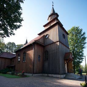 Zdjęcie nr 1: Kościół drewniany na podmurówce z kamienia, o konstrukcji zrębowej, szalowany; jednonawowy, orientowany; wieża o konstrukcji słupowej.
Prezbiterium na planie prostokąta zamkniętego trójbocznie, od północy przylega prostokątna w rzucie zakrystia; nawa na planie prostokąta, z przylegającą od południa kruchtą na rzucie kwadratu; dobudowana nawa na planie dłuższego od poprzedniej prostokąta, od zachodu wieża na planie kwadratu, częściowo wtopiona w ścianę zamykającą nawę, z wyodrębnionymi dwoma pomieszczeniami flankującymi ją.
Nawy i prezbiterium nakryte stropami, oddzielone od siebie szerokimi arkadami zamkniętymi łukami odcinkowymi. W zachodniej części większej nawy prosty parapet chóru muzycznego wsparty na dwóch drewnianych filarach; prospekt organowy przepruwa strop w przestrzeń wieży. Posadzka z płyt ceramicznych. Otwory okienne w formie stojącego prostokąta zamkniętego łukiem półkolistym, obwiedzione listwowymi opaskami, z kwaterowymi podziałami; od strony południowej – jedno w prezbiterium i po dwa w każdej części nawy, od strony północnej po dwa w każdej części nawy, od zachodniej dwa niewielkie flankujące wieżę. W zakrystii analogiczny otwór okienny od wschodu i mniejszy od północy. Otwory wejściowe: z prezbiterium do zakrystii drzwi płycinowe w futrynie; w przejściu z mniejszej nawy do kruchty drzwi płycinowe w futrynie; w przejściu z przyziemia wieży do większej nawy otwór w formie stojącego prostokąta z wklęsłymi górnymi narożami, obwiedziony listwowymi opaskami. 
Ściany z zewnątrz szalowane z listwowaniem. Trzy dachy z osobnymi kalenicami, nad prezbiterium wielospadowy; nad dwiema nawami dwuspadowe, zakończone daszkami okapowymi; kryte ceramiczną dachówką. Wieżyczka na sygnaturkę na kalenicy nad mniejszą nawą, obita blachą, zamknięta daszkiem wieżowym. 
Wieża o ścianach zwężających się ku górze, trójkondygnacyjna. Dolna kondygnacja zamknięta gzymsem, a dwie wyższe daszkami okapowymi. Całość zwieńczona hełmem ostrosłupowym z latarnią przeprutą oknami. Otwory okienne: w pierwszej kondygnacji na ścianie wschodniej i zachodniej w formie stojącego prostokąta zamkniętego łukiem półkolistym, obwiedzione listwowymi opaskami, z kwaterowymi podziałami; w drugiej kondygnacji z trzech stron okulusy, w trzeciej z czterech stron niewielkie okienka. Otwór wejściowy od zachodu, na pięciu kamiennych stopniach, drzwi deskowe-spągowe, dwuskrzydłowe, w odrzwiach belkowych; nakryty daszkiem dwuspadowym.
