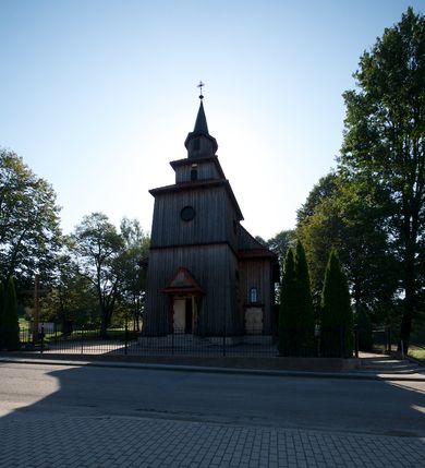 Zdjęcie nr 3: Kościół drewniany na podmurówce z kamienia, o konstrukcji zrębowej, szalowany; jednonawowy, orientowany; wieża o konstrukcji słupowej.
Prezbiterium na planie prostokąta zamkniętego trójbocznie, od północy przylega prostokątna w rzucie zakrystia; nawa na planie prostokąta, z przylegającą od południa kruchtą na rzucie kwadratu; dobudowana nawa na planie dłuższego od poprzedniej prostokąta, od zachodu wieża na planie kwadratu, częściowo wtopiona w ścianę zamykającą nawę, z wyodrębnionymi dwoma pomieszczeniami flankującymi ją.
Nawy i prezbiterium nakryte stropami, oddzielone od siebie szerokimi arkadami zamkniętymi łukami odcinkowymi. W zachodniej części większej nawy prosty parapet chóru muzycznego wsparty na dwóch drewnianych filarach; prospekt organowy przepruwa strop w przestrzeń wieży. Posadzka z płyt ceramicznych. Otwory okienne w formie stojącego prostokąta zamkniętego łukiem półkolistym, obwiedzione listwowymi opaskami, z kwaterowymi podziałami; od strony południowej – jedno w prezbiterium i po dwa w każdej części nawy, od strony północnej po dwa w każdej części nawy, od zachodniej dwa niewielkie flankujące wieżę. W zakrystii analogiczny otwór okienny od wschodu i mniejszy od północy. Otwory wejściowe: z prezbiterium do zakrystii drzwi płycinowe w futrynie; w przejściu z mniejszej nawy do kruchty drzwi płycinowe w futrynie; w przejściu z przyziemia wieży do większej nawy otwór w formie stojącego prostokąta z wklęsłymi górnymi narożami, obwiedziony listwowymi opaskami. 
Ściany z zewnątrz szalowane z listwowaniem. Trzy dachy z osobnymi kalenicami, nad prezbiterium wielospadowy; nad dwiema nawami dwuspadowe, zakończone daszkami okapowymi; kryte ceramiczną dachówką. Wieżyczka na sygnaturkę na kalenicy nad mniejszą nawą, obita blachą, zamknięta daszkiem wieżowym. 
Wieża o ścianach zwężających się ku górze, trójkondygnacyjna. Dolna kondygnacja zamknięta gzymsem, a dwie wyższe daszkami okapowymi. Całość zwieńczona hełmem ostrosłupowym z latarnią przeprutą oknami. Otwory okienne: w pierwszej kondygnacji na ścianie wschodniej i zachodniej w formie stojącego prostokąta zamkniętego łukiem półkolistym, obwiedzione listwowymi opaskami, z kwaterowymi podziałami; w drugiej kondygnacji z trzech stron okulusy, w trzeciej z czterech stron niewielkie okienka. Otwór wejściowy od zachodu, na pięciu kamiennych stopniach, drzwi deskowe-spągowe, dwuskrzydłowe, w odrzwiach belkowych; nakryty daszkiem dwuspadowym.
