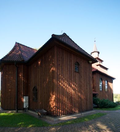 Zdjęcie nr 6: Kościół drewniany na podmurówce z kamienia, o konstrukcji zrębowej, szalowany; jednonawowy, orientowany; wieża o konstrukcji słupowej.
Prezbiterium na planie prostokąta zamkniętego trójbocznie, od północy przylega prostokątna w rzucie zakrystia; nawa na planie prostokąta, z przylegającą od południa kruchtą na rzucie kwadratu; dobudowana nawa na planie dłuższego od poprzedniej prostokąta, od zachodu wieża na planie kwadratu, częściowo wtopiona w ścianę zamykającą nawę, z wyodrębnionymi dwoma pomieszczeniami flankującymi ją.
Nawy i prezbiterium nakryte stropami, oddzielone od siebie szerokimi arkadami zamkniętymi łukami odcinkowymi. W zachodniej części większej nawy prosty parapet chóru muzycznego wsparty na dwóch drewnianych filarach; prospekt organowy przepruwa strop w przestrzeń wieży. Posadzka z płyt ceramicznych. Otwory okienne w formie stojącego prostokąta zamkniętego łukiem półkolistym, obwiedzione listwowymi opaskami, z kwaterowymi podziałami; od strony południowej – jedno w prezbiterium i po dwa w każdej części nawy, od strony północnej po dwa w każdej części nawy, od zachodniej dwa niewielkie flankujące wieżę. W zakrystii analogiczny otwór okienny od wschodu i mniejszy od północy. Otwory wejściowe: z prezbiterium do zakrystii drzwi płycinowe w futrynie; w przejściu z mniejszej nawy do kruchty drzwi płycinowe w futrynie; w przejściu z przyziemia wieży do większej nawy otwór w formie stojącego prostokąta z wklęsłymi górnymi narożami, obwiedziony listwowymi opaskami. 
Ściany z zewnątrz szalowane z listwowaniem. Trzy dachy z osobnymi kalenicami, nad prezbiterium wielospadowy; nad dwiema nawami dwuspadowe, zakończone daszkami okapowymi; kryte ceramiczną dachówką. Wieżyczka na sygnaturkę na kalenicy nad mniejszą nawą, obita blachą, zamknięta daszkiem wieżowym. 
Wieża o ścianach zwężających się ku górze, trójkondygnacyjna. Dolna kondygnacja zamknięta gzymsem, a dwie wyższe daszkami okapowymi. Całość zwieńczona hełmem ostrosłupowym z latarnią przeprutą oknami. Otwory okienne: w pierwszej kondygnacji na ścianie wschodniej i zachodniej w formie stojącego prostokąta zamkniętego łukiem półkolistym, obwiedzione listwowymi opaskami, z kwaterowymi podziałami; w drugiej kondygnacji z trzech stron okulusy, w trzeciej z czterech stron niewielkie okienka. Otwór wejściowy od zachodu, na pięciu kamiennych stopniach, drzwi deskowe-spągowe, dwuskrzydłowe, w odrzwiach belkowych; nakryty daszkiem dwuspadowym.
