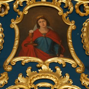 Zdjęcie nr 1: Obraz o fantazyjnej formie zbliżonej do trapezu, od góry zamknięty łukiem odcinkowym z uskokiem, o wklęsłych bokach  i dolnej krawędzi. W centrum kompozycji św. Barbara ukazana frontalnie, w półpostaci. Głowa lekko przechylona w prawo. W lewej opuszczonej ręce trzyma rękojeść miecza skierowanego w dół, w prawej podtrzymuje księgę, na której stoi kielich z hostią. Twarz ma owalną, o regularnych rysach, owalnych oczach skierowanych w górę, prostych łukach brwiowych, wąskim prostym nosie oraz małych ustach. Włosy upięte po bokach głowy. Na głowie ma koronę otwartą. Ubrana jest w niebieską suknię o złoconej lamówce oraz czerwony płaszcz zarzucony na ramiona i zapięty na piersi klamrą w formie kwiatu. Z tyłu głowy widoczny biały welon. Głowę świętej otacza nimb. Postać ukazana na cieniowanym, brązowym tle, rozjaśnionym w górnej części obrazu. 
