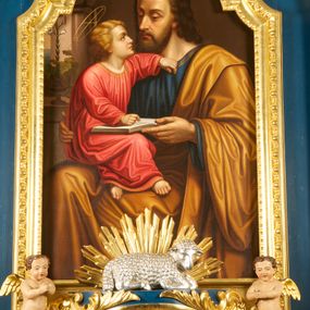 Zdjęcie nr 1: Obraz w formie stojącego prostokąta zamkniętego łukiem półkolistym. W centrum kompozycji ukazany św. Józef trzymający na kolanach Dzieciątko Jezus i nauczający je. Józef przedstawiony w pozycji siedzącej, do wysokości łydek, zwrócony w trzech czwartych w lewo. Prawą ręką obejmuje Dzieciątko, lewą przytrzymuje otwartą księgę na jego kolanach Twarz ma pociągłą, o wysokim czole, dużych, okrągłych oczach, skierowanych w dół, garbatym nosie i pełnych ustach; okoloną kręconymi włosami sięgającymi ramion oraz krótką brodą i wąsami. Nad głową Józefa nimb. Ubrany jest w niebieską tunikę ze złoconą lamówką oraz obficie drapowany żółty płaszcz przewiązany przez lewe ramię i opadający na kolana. Dzieciątko w pozycji siedzącej, zwrócone w trzech czwartych w prawo, z głową ukazaną z profilu. Lewą, ugiętą rękę opiera na piersi Józefa, prawą kładzie na księdze, opartej na jego kolanach. Nogi ma skrzyżowane. Twarz o młodzieńczych rysach, dużych oczach skierowanych w górę, małym nosie i pełnych ustach, okoloną jasnymi, kręconymi włosami. Dzieciątko ubrane w jasnoczerwoną, luźną i silnie drapowaną tunikę ze złoconą lamówką. Nad głową Dzieciątka nimb z krzyżem. Scena ukazana we wnętrzu z widocznym po lewej tronie oknem, na którego parapecie stoi wazon z gałązką lilii oraz po którym pnie się winna latorośl. 
