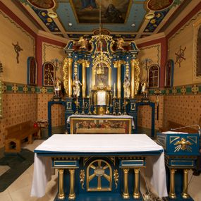 Zdjęcie nr 1: Ołtarz drewniany, prostopadłościenny, z kamienną mensą. Antepedium w formie obrazu z przedstawieniem Ostatniej Wieczerzy, ujętego profilowaną ramą. Na ołtarzu ustawione tabernakulum z tronem wystawienia. 
Nastawa architektoniczna, jednokondygnacyjna ze zwieńczeniem, trójosiowa z bramkami, ustawiona na dwustrefowym cokole z wyłamanymi czterema prostopadłościanami. Oś środkowa ujęta dwiema parami pilastrów oraz parą kolumn, na cokołach zwróconych pod kątem do wewnątrz ołtarza. Osie zewnętrzne ujęte parą pilastrów i stojących na ich tle kolumn. Wszystkie podpory dźwigają imposty, na osiach środkowy podpór zwrócone pod kątem do wewnątrz. Na parze skrajnych impostów fragmenty przerwanego, falistego przyczółka. W polu środkowym nisza w formie stojącego prostokąta zamkniętego łukiem półkolistym nadwieszonym, z uskokiem, ujęta profilowaną ramą, z obrazem Nauczania Marii. Na osiach bocznych figury św. Piotra i św. Pawła ustawione na wspornikach Zwieńczenie niearchitektoniczne, o formie zbliżonej do trapezu, o wklęsłych bokach z uszakami, zamknięte fragmentem falistego gzymsu. W polu obraz o fantazyjnej formie zbliżonej do trapezu z przedstawieniem św. Barbary, ujęty ornamentalną ramą. Zwieńczenie flankują dwie figury klęczących aniołów na cokołach. Nastawa dekorowana rocaille&#039;m w przestrzeni nad polem głównym oraz w partii zwieńczenia, ujęta uszami utworzonymi z rocaille&#039;u, kampanuli i ornamentu roślinnego. Na osiach bocznych zwisy kwiatowe. Bramki w formie przejść o wykroju stojącego prostokąta o wklęsłych górnych narożach, zamkniętego dwiema woltami i cokołami z imitacją puklowania, na których stoją figury niezidentyfikowanych monarchów. Struktura polichromowana w kolorze niebieskim, kolumny, profile i ornamentyka złocone. 






