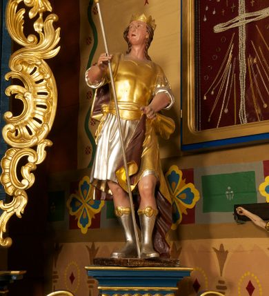 Zdjęcie nr 5: Ołtarz drewniany, prostopadłościenny, z kamienną mensą. Antepedium w formie obrazu z przedstawieniem Ostatniej Wieczerzy, ujętego profilowaną ramą. Na ołtarzu ustawione tabernakulum z tronem wystawienia. 
Nastawa architektoniczna, jednokondygnacyjna ze zwieńczeniem, trójosiowa z bramkami, ustawiona na dwustrefowym cokole z wyłamanymi czterema prostopadłościanami. Oś środkowa ujęta dwiema parami pilastrów oraz parą kolumn, na cokołach zwróconych pod kątem do wewnątrz ołtarza. Osie zewnętrzne ujęte parą pilastrów i stojących na ich tle kolumn. Wszystkie podpory dźwigają imposty, na osiach środkowy podpór zwrócone pod kątem do wewnątrz. Na parze skrajnych impostów fragmenty przerwanego, falistego przyczółka. W polu środkowym nisza w formie stojącego prostokąta zamkniętego łukiem półkolistym nadwieszonym, z uskokiem, ujęta profilowaną ramą, z obrazem Nauczania Marii. Na osiach bocznych figury św. Piotra i św. Pawła ustawione na wspornikach Zwieńczenie niearchitektoniczne, o formie zbliżonej do trapezu, o wklęsłych bokach z uszakami, zamknięte fragmentem falistego gzymsu. W polu obraz o fantazyjnej formie zbliżonej do trapezu z przedstawieniem św. Barbary, ujęty ornamentalną ramą. Zwieńczenie flankują dwie figury klęczących aniołów na cokołach. Nastawa dekorowana rocaille'm w przestrzeni nad polem głównym oraz w partii zwieńczenia, ujęta uszami utworzonymi z rocaille'u, kampanuli i ornamentu roślinnego. Na osiach bocznych zwisy kwiatowe. Bramki w formie przejść o wykroju stojącego prostokąta o wklęsłych górnych narożach, zamkniętego dwiema woltami i cokołami z imitacją puklowania, na których stoją figury niezidentyfikowanych monarchów. Struktura polichromowana w kolorze niebieskim, kolumny, profile i ornamentyka złocone. 






