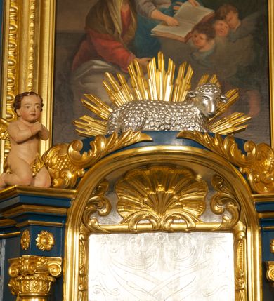 Zdjęcie nr 6: Ołtarz drewniany, prostopadłościenny, z kamienną mensą. Antepedium w formie obrazu z przedstawieniem Ostatniej Wieczerzy, ujętego profilowaną ramą. Na ołtarzu ustawione tabernakulum z tronem wystawienia. 
Nastawa architektoniczna, jednokondygnacyjna ze zwieńczeniem, trójosiowa z bramkami, ustawiona na dwustrefowym cokole z wyłamanymi czterema prostopadłościanami. Oś środkowa ujęta dwiema parami pilastrów oraz parą kolumn, na cokołach zwróconych pod kątem do wewnątrz ołtarza. Osie zewnętrzne ujęte parą pilastrów i stojących na ich tle kolumn. Wszystkie podpory dźwigają imposty, na osiach środkowy podpór zwrócone pod kątem do wewnątrz. Na parze skrajnych impostów fragmenty przerwanego, falistego przyczółka. W polu środkowym nisza w formie stojącego prostokąta zamkniętego łukiem półkolistym nadwieszonym, z uskokiem, ujęta profilowaną ramą, z obrazem Nauczania Marii. Na osiach bocznych figury św. Piotra i św. Pawła ustawione na wspornikach Zwieńczenie niearchitektoniczne, o formie zbliżonej do trapezu, o wklęsłych bokach z uszakami, zamknięte fragmentem falistego gzymsu. W polu obraz o fantazyjnej formie zbliżonej do trapezu z przedstawieniem św. Barbary, ujęty ornamentalną ramą. Zwieńczenie flankują dwie figury klęczących aniołów na cokołach. Nastawa dekorowana rocaille'm w przestrzeni nad polem głównym oraz w partii zwieńczenia, ujęta uszami utworzonymi z rocaille'u, kampanuli i ornamentu roślinnego. Na osiach bocznych zwisy kwiatowe. Bramki w formie przejść o wykroju stojącego prostokąta o wklęsłych górnych narożach, zamkniętego dwiema woltami i cokołami z imitacją puklowania, na których stoją figury niezidentyfikowanych monarchów. Struktura polichromowana w kolorze niebieskim, kolumny, profile i ornamentyka złocone. 






