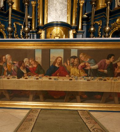 Zdjęcie nr 9: Ołtarz drewniany, prostopadłościenny, z kamienną mensą. Antepedium w formie obrazu z przedstawieniem Ostatniej Wieczerzy, ujętego profilowaną ramą. Na ołtarzu ustawione tabernakulum z tronem wystawienia. 
Nastawa architektoniczna, jednokondygnacyjna ze zwieńczeniem, trójosiowa z bramkami, ustawiona na dwustrefowym cokole z wyłamanymi czterema prostopadłościanami. Oś środkowa ujęta dwiema parami pilastrów oraz parą kolumn, na cokołach zwróconych pod kątem do wewnątrz ołtarza. Osie zewnętrzne ujęte parą pilastrów i stojących na ich tle kolumn. Wszystkie podpory dźwigają imposty, na osiach środkowy podpór zwrócone pod kątem do wewnątrz. Na parze skrajnych impostów fragmenty przerwanego, falistego przyczółka. W polu środkowym nisza w formie stojącego prostokąta zamkniętego łukiem półkolistym nadwieszonym, z uskokiem, ujęta profilowaną ramą, z obrazem Nauczania Marii. Na osiach bocznych figury św. Piotra i św. Pawła ustawione na wspornikach Zwieńczenie niearchitektoniczne, o formie zbliżonej do trapezu, o wklęsłych bokach z uszakami, zamknięte fragmentem falistego gzymsu. W polu obraz o fantazyjnej formie zbliżonej do trapezu z przedstawieniem św. Barbary, ujęty ornamentalną ramą. Zwieńczenie flankują dwie figury klęczących aniołów na cokołach. Nastawa dekorowana rocaille'm w przestrzeni nad polem głównym oraz w partii zwieńczenia, ujęta uszami utworzonymi z rocaille'u, kampanuli i ornamentu roślinnego. Na osiach bocznych zwisy kwiatowe. Bramki w formie przejść o wykroju stojącego prostokąta o wklęsłych górnych narożach, zamkniętego dwiema woltami i cokołami z imitacją puklowania, na których stoją figury niezidentyfikowanych monarchów. Struktura polichromowana w kolorze niebieskim, kolumny, profile i ornamentyka złocone. 






