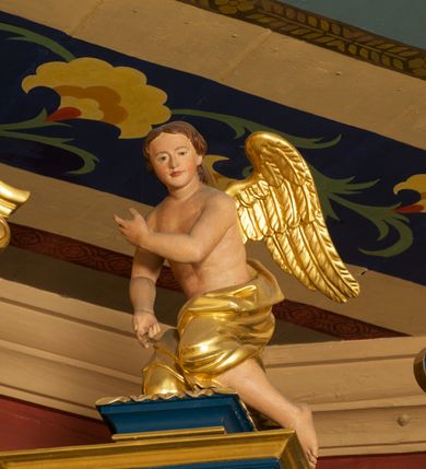 Zdjęcie nr 13: Ołtarz drewniany, prostopadłościenny, z kamienną mensą. Antepedium w formie obrazu z przedstawieniem Ostatniej Wieczerzy, ujętego profilowaną ramą. Na ołtarzu ustawione tabernakulum z tronem wystawienia. 
Nastawa architektoniczna, jednokondygnacyjna ze zwieńczeniem, trójosiowa z bramkami, ustawiona na dwustrefowym cokole z wyłamanymi czterema prostopadłościanami. Oś środkowa ujęta dwiema parami pilastrów oraz parą kolumn, na cokołach zwróconych pod kątem do wewnątrz ołtarza. Osie zewnętrzne ujęte parą pilastrów i stojących na ich tle kolumn. Wszystkie podpory dźwigają imposty, na osiach środkowy podpór zwrócone pod kątem do wewnątrz. Na parze skrajnych impostów fragmenty przerwanego, falistego przyczółka. W polu środkowym nisza w formie stojącego prostokąta zamkniętego łukiem półkolistym nadwieszonym, z uskokiem, ujęta profilowaną ramą, z obrazem Nauczania Marii. Na osiach bocznych figury św. Piotra i św. Pawła ustawione na wspornikach Zwieńczenie niearchitektoniczne, o formie zbliżonej do trapezu, o wklęsłych bokach z uszakami, zamknięte fragmentem falistego gzymsu. W polu obraz o fantazyjnej formie zbliżonej do trapezu z przedstawieniem św. Barbary, ujęty ornamentalną ramą. Zwieńczenie flankują dwie figury klęczących aniołów na cokołach. Nastawa dekorowana rocaille&#039;m w przestrzeni nad polem głównym oraz w partii zwieńczenia, ujęta uszami utworzonymi z rocaille&#039;u, kampanuli i ornamentu roślinnego. Na osiach bocznych zwisy kwiatowe. Bramki w formie przejść o wykroju stojącego prostokąta o wklęsłych górnych narożach, zamkniętego dwiema woltami i cokołami z imitacją puklowania, na których stoją figury niezidentyfikowanych monarchów. Struktura polichromowana w kolorze niebieskim, kolumny, profile i ornamentyka złocone. 






