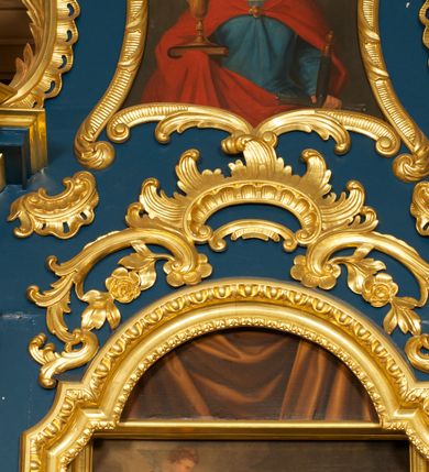 Zdjęcie nr 14: Ołtarz drewniany, prostopadłościenny, z kamienną mensą. Antepedium w formie obrazu z przedstawieniem Ostatniej Wieczerzy, ujętego profilowaną ramą. Na ołtarzu ustawione tabernakulum z tronem wystawienia. 
Nastawa architektoniczna, jednokondygnacyjna ze zwieńczeniem, trójosiowa z bramkami, ustawiona na dwustrefowym cokole z wyłamanymi czterema prostopadłościanami. Oś środkowa ujęta dwiema parami pilastrów oraz parą kolumn, na cokołach zwróconych pod kątem do wewnątrz ołtarza. Osie zewnętrzne ujęte parą pilastrów i stojących na ich tle kolumn. Wszystkie podpory dźwigają imposty, na osiach środkowy podpór zwrócone pod kątem do wewnątrz. Na parze skrajnych impostów fragmenty przerwanego, falistego przyczółka. W polu środkowym nisza w formie stojącego prostokąta zamkniętego łukiem półkolistym nadwieszonym, z uskokiem, ujęta profilowaną ramą, z obrazem Nauczania Marii. Na osiach bocznych figury św. Piotra i św. Pawła ustawione na wspornikach Zwieńczenie niearchitektoniczne, o formie zbliżonej do trapezu, o wklęsłych bokach z uszakami, zamknięte fragmentem falistego gzymsu. W polu obraz o fantazyjnej formie zbliżonej do trapezu z przedstawieniem św. Barbary, ujęty ornamentalną ramą. Zwieńczenie flankują dwie figury klęczących aniołów na cokołach. Nastawa dekorowana rocaille'm w przestrzeni nad polem głównym oraz w partii zwieńczenia, ujęta uszami utworzonymi z rocaille'u, kampanuli i ornamentu roślinnego. Na osiach bocznych zwisy kwiatowe. Bramki w formie przejść o wykroju stojącego prostokąta o wklęsłych górnych narożach, zamkniętego dwiema woltami i cokołami z imitacją puklowania, na których stoją figury niezidentyfikowanych monarchów. Struktura polichromowana w kolorze niebieskim, kolumny, profile i ornamentyka złocone. 






