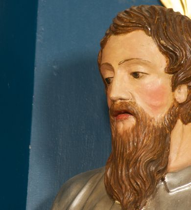 Zdjęcie nr 3: Rzeźba pełnoplastyczna, ustawiona na niskiej podstawie. Figura ukazana frontalnie, w kontrapoście, z głową skierowaną w prawo. W lewej, opuszczonej ręce trzyma przy boku miecz, skierowany ostrzem w dół, prawą kładzie na piersi. Twarz ma szeroką, o niskim czole, niewielkich, migdałowatych i półprzymkniętych oczach, małym nosie i rozchylonych ustach. Włosy lekko falowane, krótkie, silnie przylegające do głowy. Twarz okolona długą lekko falowaną brodą i wąsami. Postać ubrana w długą, srebrzoną tunikę z kołnierzykiem, przepasaną w pasie oraz złocony płaszcz przerzucony przez prawe ramię i opadający na plecy i lewy bok. Na stopach ma złocone sandały. Polichromia ciała naturalistyczna. 






