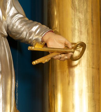 Zdjęcie nr 5: Rzeźba pełnoplastyczna, ustawiona na niskiej podstawie. Figura ukazana frontalnie, w lekkim odchyleniu, z uniesioną głową skierowaną w lewo. W lewej, wyciągniętej do przodu ręce trzyma skrzyżowane dwa klucze, w prawej, ugiętej ręce trzyma zamkniętą księgę, opartą na ugiętej nodze, ustawionej na stopniu. Twarz ma szeroką, o wysokim czole, niewielkich migdałowatych oczach, małych nosie i ustach. Włosy lekko kręcone, krótkie, silnie przylegające do głowy, z zaznaczoną łysiną i puklem nad czołem. Twarz okolona krótką, kręconą brodą z wąsami. Postać ubrana w długą, srebrzoną tunikę z kołnierzykiem, przepasaną w pasie oraz złocony płaszcz przerzucony przez prawe ramię i opadający na plecy. Na stopach ma złocone sandały. Polichromią ciała naturalistyczna. 






