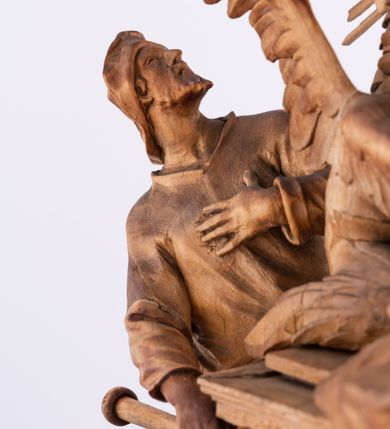 Zdjęcie nr 2: Tabernakulum w formie Arki Przymierza, adorowanej przez dwie klęczące figury św. Jana i starotestamentowego arcykapłana, dwie stojące postacie lewitów oraz klęczących aniołów, zwieńczonej glorią promienistą z okiem Opatrzności. Arka w formie prostopadłościennej szafki z dwoma drążkami do noszenia jest od frontu podzielone na trzy pola: środkowe zamknięte łukiem wklęsło-wypukłym i boczne o ćwierćkoliście wyciętych narożach. Pole środkowe stanowią drzwiczki z rytymi cyframi Dekalogu, a w bocznych znajdują się kłosy zbóż i winne grono. Na skłębionych chmurach z podestem leży baranek. Nad nim widnieje znacznej wielkości gloria promienista z wieńcem chmur i umieszczonym w nim okiem Opatrzności oraz cztery uskrzydlone główki anielskie. Nad parą główek w górnej części papieska tiara ze skrzyżowanymi kluczami. Po bokach baranka dwa klęczące, uskrzydlone nagie aniołki o rękach i nogach utworzonych z piór. Obok arki dwie postacie lewitów ubranych w długie szaty, w różnicowanych pozach i gestach. Poniżej klęczą postacie św. Jana z księgą i orłem obok niego i kapłana w tradycyjnym starotestamentowym stroju – efodzie czyli tunice i płaszczu wierzchnim przepasanym na biodrach, z pektorałem na piersi i czapką na głowie. 