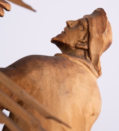 Zdjęcie nr 11: Tabernakulum w formie Arki Przymierza, adorowanej przez dwie klęczące figury św. Jana i starotestamentowego arcykapłana, dwie stojące postacie lewitów oraz klęczących aniołów, zwieńczonej glorią promienistą z okiem Opatrzności. Arka w formie prostopadłościennej szafki z dwoma drążkami do noszenia jest od frontu podzielone na trzy pola: środkowe zamknięte łukiem wklęsło-wypukłym i boczne o ćwierćkoliście wyciętych narożach. Pole środkowe stanowią drzwiczki z rytymi cyframi Dekalogu, a w bocznych znajdują się kłosy zbóż i winne grono. Na skłębionych chmurach z podestem leży baranek. Nad nim widnieje znacznej wielkości gloria promienista z wieńcem chmur i umieszczonym w nim okiem Opatrzności oraz cztery uskrzydlone główki anielskie. Nad parą główek w górnej części papieska tiara ze skrzyżowanymi kluczami. Po bokach baranka dwa klęczące, uskrzydlone nagie aniołki o rękach i nogach utworzonych z piór. Obok arki dwie postacie lewitów ubranych w długie szaty, w różnicowanych pozach i gestach. Poniżej klęczą postacie św. Jana z księgą i orłem obok niego i kapłana w tradycyjnym starotestamentowym stroju – efodzie czyli tunice i płaszczu wierzchnim przepasanym na biodrach, z pektorałem na piersi i czapką na głowie. 