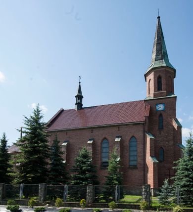Zdjęcie nr 1: Kościół ceglany z kamiennym przyziemiem, na planie prostokąta z węższym i niższym prezbiterium flankowanym dwoma aneksami wystającymi poza lico nawy i wieżą od zachodu. Kościół orientowany, jednonawowy, czteroprzęsłowy z węższym, jednoprzęsłowym prezbiterium zamkniętym trójbocznie, z kruchtą w przyziemiu wieży. Nawa artykułowana półfilarami o ściętych narożach, przechodzących w gurty krzyżowo-żebrowego sklepienia. W nawie i prezbiterium okna prostokątne zamknięte łukiem ostrym; główne wejście od wschodu. Identyczne okna w aneksach przy prezbiterium. Aneksy dwuprzęsłowe ujęte wielobocznymi filarami, zamknięte trójbocznie z parasolowym sklepieniem. Chór muzyczny w czwartym przęśle nawy, wsparty na wielobocznych filarach z drewnianym parapetem ozdobionym ostrołukowymi blendami. Kruchta węższa od nawy, zasklepiona krzyżowo. Fasada węższa od nawy, ujęta przyporami w narożach, między którymi ostrołukowe wejście. W drugiej kondygnacji oddzielonej parapetem wysokie okno zamknięte łukiem ostrym, nad którym tarcza zegara. Nad fasadą ośmioboczna wieża. W wieży na przemian okna i płyciny, zamknięte łukiem ostrym. Trójboczne prezbiterium w narożach ujęte przyporami sięgającymi połowy wysokości, między którymi ostrołukowe okna. Aneksy na planie prostokąta z przyporami na narożach oraz jedną w części bocznej. Czteroosiowa ściana nawy i naroża oddzielone przyporami, między którymi ostrołukowo zakończone okna. Hełm wieży w formie ośmiobocznego stożka, załamującego się w partii dolnej. Nawa z dwuspadowym dachem z wieżyczką na sygnaturkę nad pierwszym przęsłem.