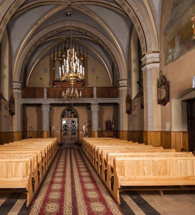 Zdjęcie nr 14: Kościół ceglany z kamiennym przyziemiem, na planie prostokąta z węższym i niższym prezbiterium flankowanym dwoma aneksami wystającymi poza lico nawy i wieżą od zachodu. Kościół orientowany, jednonawowy, czteroprzęsłowy z węższym, jednoprzęsłowym prezbiterium zamkniętym trójbocznie, z kruchtą w przyziemiu wieży. Nawa artykułowana półfilarami o ściętych narożach, przechodzących w gurty krzyżowo-żebrowego sklepienia. W nawie i prezbiterium okna prostokątne zamknięte łukiem ostrym; główne wejście od wschodu. Identyczne okna w aneksach przy prezbiterium. Aneksy dwuprzęsłowe ujęte wielobocznymi filarami, zamknięte trójbocznie z parasolowym sklepieniem. Chór muzyczny w czwartym przęśle nawy, wsparty na wielobocznych filarach z drewnianym parapetem ozdobionym ostrołukowymi blendami. Kruchta węższa od nawy, zasklepiona krzyżowo. Fasada węższa od nawy, ujęta przyporami w narożach, między którymi ostrołukowe wejście. W drugiej kondygnacji oddzielonej parapetem wysokie okno zamknięte łukiem ostrym, nad którym tarcza zegara. Nad fasadą ośmioboczna wieża. W wieży na przemian okna i płyciny, zamknięte łukiem ostrym. Trójboczne prezbiterium w narożach ujęte przyporami sięgającymi połowy wysokości, między którymi ostrołukowe okna. Aneksy na planie prostokąta z przyporami na narożach oraz jedną w części bocznej. Czteroosiowa ściana nawy i naroża oddzielone przyporami, między którymi ostrołukowo zakończone okna. Hełm wieży w formie ośmiobocznego stożka, załamującego się w partii dolnej. Nawa z dwuspadowym dachem z wieżyczką na sygnaturkę nad pierwszym przęsłem.