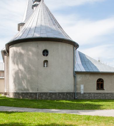 Zdjęcie nr 7: Kościół św. Rozalii w Podszklu usytuowany jest przy skrzyżowaniu dróg w centrum miejscowości na obszernym placu, na którym rosną stare jesiony. Teren przykościelny ogrodzony jest kamiennym murem z czterema murowanymi z nieregularnych kamieni kaplicami rozmieszczonymi na jego obwodzie. Wejście na teren przykościelny prowadzi przez trzy bramy umieszczone od strony północnej, każda flankowana jest przez parę obelisków. Kolejne wejście znajduje się od strony zachodniej. 

Kościół orientowany z krótkim zakończonym półkoliście prezbiterium i czworoboczną wieżą od zachodu. Do prezbiterium jest dobudowana zakrystia. Główne wejście do świątyni od strony zachodniej, drugie przez zakrystię. Od południa dobudowana została nowsza przybudówka. Nawa szersza od prezbiterium założona na planie prostokąta. Wnętrze nakryte jest drewnianym stropem z kasetonami. Nawę oświetlają pary okien na każdej ze ścian w kształcie stojących prostokątów, zamkniętych półkoliście; do prezbiterium zaś światło wpada przez okno umieszczone od strony południowej oraz mniejszy oculus na ścieni wschodniej. Chór muzyczny drewniany, wsparty na dwóch drewnianych słupach, z dostępem schodami od południowej strony nawy.

Elewacja zewnętrzna pozbawiona większych podziałów architektonicznych z wyjątkiem podokapowych gzymsów, w partii cokołowej okładzina kamienna z regularnych ciosów, wyżej kościół otynkowany. W fasadzie trójkondygnacyjna, czworoboczna wieża o zaokrąglonych narożnikach, w jednej trzeciej wysokości oddzielona daszkiem. W drugiej i trzeciej kondygnacji podziały zaznaczone jedynie przez pojedyncze otwory okienne na każdej ze ścian i kondygnacji w kształcie stojących prostokątów, zamkniętych półkoliście. Wieża nakryta ostrosłupowym hełmem. Po bokach flankowana jest przez dwie przybudówki na planie ćwierćkoła, sięgające wysokością do drugiej kondygnacji wieży. Nawę i prezbiterium nakrywa jednokalenicowy, stromy dach, pokryty blachą. Na skrzyżowaniu nawy z prezbiterium wieżyczka na sygnaturkę z latarnią. Wejście do kościoła od zachodu zaakcentowane jest dwuspadowym daszkiem z trójkątnym szczytem oraz małą wieżyczką z cebulastym hełmem.