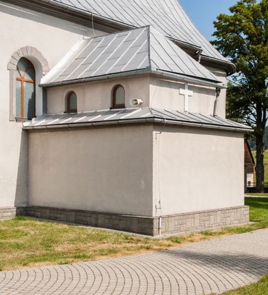 Zdjęcie nr 5: Kościół św. Rozalii w Podszklu usytuowany jest przy skrzyżowaniu dróg w centrum miejscowości na obszernym placu, na którym rosną stare jesiony. Teren przykościelny ogrodzony jest kamiennym murem z czterema murowanymi z nieregularnych kamieni kaplicami rozmieszczonymi na jego obwodzie. Wejście na teren przykościelny prowadzi przez trzy bramy umieszczone od strony północnej, każda flankowana jest przez parę obelisków. Kolejne wejście znajduje się od strony zachodniej. 

Kościół orientowany z krótkim zakończonym półkoliście prezbiterium i czworoboczną wieżą od zachodu. Do prezbiterium jest dobudowana zakrystia. Główne wejście do świątyni od strony zachodniej, drugie przez zakrystię. Od południa dobudowana została nowsza przybudówka. Nawa szersza od prezbiterium założona na planie prostokąta. Wnętrze nakryte jest drewnianym stropem z kasetonami. Nawę oświetlają pary okien na każdej ze ścian w kształcie stojących prostokątów, zamkniętych półkoliście; do prezbiterium zaś światło wpada przez okno umieszczone od strony południowej oraz mniejszy oculus na ścieni wschodniej. Chór muzyczny drewniany, wsparty na dwóch drewnianych słupach, z dostępem schodami od południowej strony nawy.

Elewacja zewnętrzna pozbawiona większych podziałów architektonicznych z wyjątkiem podokapowych gzymsów, w partii cokołowej okładzina kamienna z regularnych ciosów, wyżej kościół otynkowany. W fasadzie trójkondygnacyjna, czworoboczna wieża o zaokrąglonych narożnikach, w jednej trzeciej wysokości oddzielona daszkiem. W drugiej i trzeciej kondygnacji podziały zaznaczone jedynie przez pojedyncze otwory okienne na każdej ze ścian i kondygnacji w kształcie stojących prostokątów, zamkniętych półkoliście. Wieża nakryta ostrosłupowym hełmem. Po bokach flankowana jest przez dwie przybudówki na planie ćwierćkoła, sięgające wysokością do drugiej kondygnacji wieży. Nawę i prezbiterium nakrywa jednokalenicowy, stromy dach, pokryty blachą. Na skrzyżowaniu nawy z prezbiterium wieżyczka na sygnaturkę z latarnią. Wejście do kościoła od zachodu zaakcentowane jest dwuspadowym daszkiem z trójkątnym szczytem oraz małą wieżyczką z cebulastym hełmem.