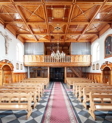 Zdjęcie nr 11: Kościół św. Rozalii w Podszklu usytuowany jest przy skrzyżowaniu dróg w centrum miejscowości na obszernym placu, na którym rosną stare jesiony. Teren przykościelny ogrodzony jest kamiennym murem z czterema murowanymi z nieregularnych kamieni kaplicami rozmieszczonymi na jego obwodzie. Wejście na teren przykościelny prowadzi przez trzy bramy umieszczone od strony północnej, każda flankowana jest przez parę obelisków. Kolejne wejście znajduje się od strony zachodniej. 

Kościół orientowany z krótkim zakończonym półkoliście prezbiterium i czworoboczną wieżą od zachodu. Do prezbiterium jest dobudowana zakrystia. Główne wejście do świątyni od strony zachodniej, drugie przez zakrystię. Od południa dobudowana została nowsza przybudówka. Nawa szersza od prezbiterium założona na planie prostokąta. Wnętrze nakryte jest drewnianym stropem z kasetonami. Nawę oświetlają pary okien na każdej ze ścian w kształcie stojących prostokątów, zamkniętych półkoliście; do prezbiterium zaś światło wpada przez okno umieszczone od strony południowej oraz mniejszy oculus na ścieni wschodniej. Chór muzyczny drewniany, wsparty na dwóch drewnianych słupach, z dostępem schodami od południowej strony nawy.

Elewacja zewnętrzna pozbawiona większych podziałów architektonicznych z wyjątkiem podokapowych gzymsów, w partii cokołowej okładzina kamienna z regularnych ciosów, wyżej kościół otynkowany. W fasadzie trójkondygnacyjna, czworoboczna wieża o zaokrąglonych narożnikach, w jednej trzeciej wysokości oddzielona daszkiem. W drugiej i trzeciej kondygnacji podziały zaznaczone jedynie przez pojedyncze otwory okienne na każdej ze ścian i kondygnacji w kształcie stojących prostokątów, zamkniętych półkoliście. Wieża nakryta ostrosłupowym hełmem. Po bokach flankowana jest przez dwie przybudówki na planie ćwierćkoła, sięgające wysokością do drugiej kondygnacji wieży. Nawę i prezbiterium nakrywa jednokalenicowy, stromy dach, pokryty blachą. Na skrzyżowaniu nawy z prezbiterium wieżyczka na sygnaturkę z latarnią. Wejście do kościoła od zachodu zaakcentowane jest dwuspadowym daszkiem z trójkątnym szczytem oraz małą wieżyczką z cebulastym hełmem.