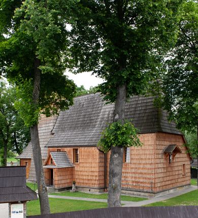 Zdjęcie nr 18: Kościół jednonawowy,  prezbiterium oddzielone ścianą tęczową z poprzeczną belką. Stropy pokryte dekoracją malarską imitującą kasetony z rozetami, z przedstawieniem Matki Boskiej z Dzieciątkiem w prezbiterium, św. Michała Archanioła w nawie oraz klęczących aniołów na ścianach. W dolnej partii ściany niebieskie, z biegnącą dookoła inskrypcją, a do jednej trzeciej wysokości od dołu w kolorze drewna. W przedsionku polichromia patronowa o motywach geometrycznych, roślinnych, zwierzęcych itd.  W nawie od zachodu chór muzyczny z dekoracją malarską roślinną i antropomorficzną. Nawa i prezbiterium naryte pozornym sklepieniem w kształcie spłaszczonej kolebki ze skośnymi fasetami. W nawie głównej jedno duże okno w kształcie stojącego prostokąta, bliżej chóru drugie, niewielkie, w kształcie leżącego; kolejne w wieży, przedsionku i prezbiterium. Główne wejście od zachodu, drugie przez kruchtę od południa, trzecie do zakrystii. Portal południowy prostokątny, osłonięty daszkiem, poniżej trójkątnego szczytu wypełnionego oknem. Od zachodu kwadratowa wieża o pochyłych ścianach pobitych gontem, z nadwieszoną, nieco występującą izbicą szalowaną pionowymi deskami, na dolnych końcach ozdobnie wycinanymi. Ściany obłożone gontem, gładkie. Nad nawą i prezbiterium dach jednokalenicowy, gontowy, wieża z ostrosłupowym hełmem. Nad nawą barokowa wieżyczka na sygnaturkę kryta blachą. 
Najcenniejszym elementem wyposażenia jest gotyckie retabulum ołtarzowe pełniące od 1935 roku rolę ołtarza głównego w miejsce rozebranego, barokowego. Oprócz niego szczególne znaczenie mają fragmenty zachowanej polichromii patronowej z około 1500 roku. 
