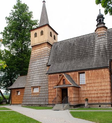 Zdjęcie nr 11: Kościół jednonawowy,  prezbiterium oddzielone ścianą tęczową z poprzeczną belką. Stropy pokryte dekoracją malarską imitującą kasetony z rozetami, z przedstawieniem Matki Boskiej z Dzieciątkiem w prezbiterium, św. Michała Archanioła w nawie oraz klęczących aniołów na ścianach. W dolnej partii ściany niebieskie, z biegnącą dookoła inskrypcją, a do jednej trzeciej wysokości od dołu w kolorze drewna. W przedsionku polichromia patronowa o motywach geometrycznych, roślinnych, zwierzęcych itd.  W nawie od zachodu chór muzyczny z dekoracją malarską roślinną i antropomorficzną. Nawa i prezbiterium naryte pozornym sklepieniem w kształcie spłaszczonej kolebki ze skośnymi fasetami. W nawie głównej jedno duże okno w kształcie stojącego prostokąta, bliżej chóru drugie, niewielkie, w kształcie leżącego; kolejne w wieży, przedsionku i prezbiterium. Główne wejście od zachodu, drugie przez kruchtę od południa, trzecie do zakrystii. Portal południowy prostokątny, osłonięty daszkiem, poniżej trójkątnego szczytu wypełnionego oknem. Od zachodu kwadratowa wieża o pochyłych ścianach pobitych gontem, z nadwieszoną, nieco występującą izbicą szalowaną pionowymi deskami, na dolnych końcach ozdobnie wycinanymi. Ściany obłożone gontem, gładkie. Nad nawą i prezbiterium dach jednokalenicowy, gontowy, wieża z ostrosłupowym hełmem. Nad nawą barokowa wieżyczka na sygnaturkę kryta blachą. 
Najcenniejszym elementem wyposażenia jest gotyckie retabulum ołtarzowe pełniące od 1935 roku rolę ołtarza głównego w miejsce rozebranego, barokowego. Oprócz niego szczególne znaczenie mają fragmenty zachowanej polichromii patronowej z około 1500 roku. 
