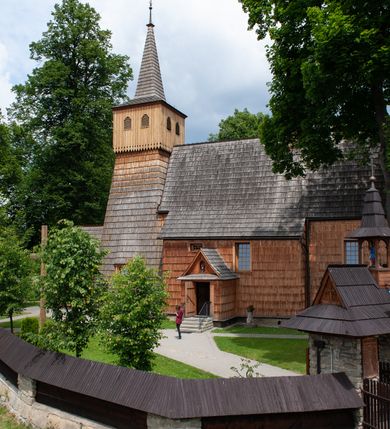 Zdjęcie nr 8: Kościół jednonawowy,  prezbiterium oddzielone ścianą tęczową z poprzeczną belką. Stropy pokryte dekoracją malarską imitującą kasetony z rozetami, z przedstawieniem Matki Boskiej z Dzieciątkiem w prezbiterium, św. Michała Archanioła w nawie oraz klęczących aniołów na ścianach. W dolnej partii ściany niebieskie, z biegnącą dookoła inskrypcją, a do jednej trzeciej wysokości od dołu w kolorze drewna. W przedsionku polichromia patronowa o motywach geometrycznych, roślinnych, zwierzęcych itd.  W nawie od zachodu chór muzyczny z dekoracją malarską roślinną i antropomorficzną. Nawa i prezbiterium naryte pozornym sklepieniem w kształcie spłaszczonej kolebki ze skośnymi fasetami. W nawie głównej jedno duże okno w kształcie stojącego prostokąta, bliżej chóru drugie, niewielkie, w kształcie leżącego; kolejne w wieży, przedsionku i prezbiterium. Główne wejście od zachodu, drugie przez kruchtę od południa, trzecie do zakrystii. Portal południowy prostokątny, osłonięty daszkiem, poniżej trójkątnego szczytu wypełnionego oknem. Od zachodu kwadratowa wieża o pochyłych ścianach pobitych gontem, z nadwieszoną, nieco występującą izbicą szalowaną pionowymi deskami, na dolnych końcach ozdobnie wycinanymi. Ściany obłożone gontem, gładkie. Nad nawą i prezbiterium dach jednokalenicowy, gontowy, wieża z ostrosłupowym hełmem. Nad nawą barokowa wieżyczka na sygnaturkę kryta blachą. 
Najcenniejszym elementem wyposażenia jest gotyckie retabulum ołtarzowe pełniące od 1935 roku rolę ołtarza głównego w miejsce rozebranego, barokowego. Oprócz niego szczególne znaczenie mają fragmenty zachowanej polichromii patronowej z około 1500 roku. 
